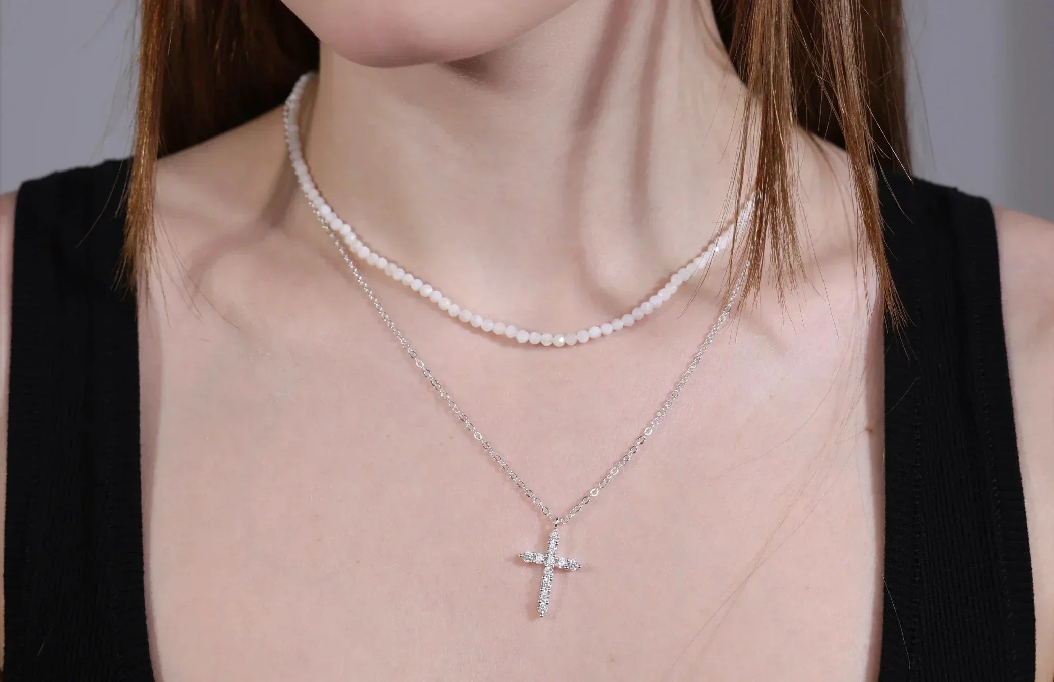 Model wearing minimalist layered cross necklace with white beaded choker – hypoallergenic jewelry by Velvet Luminance