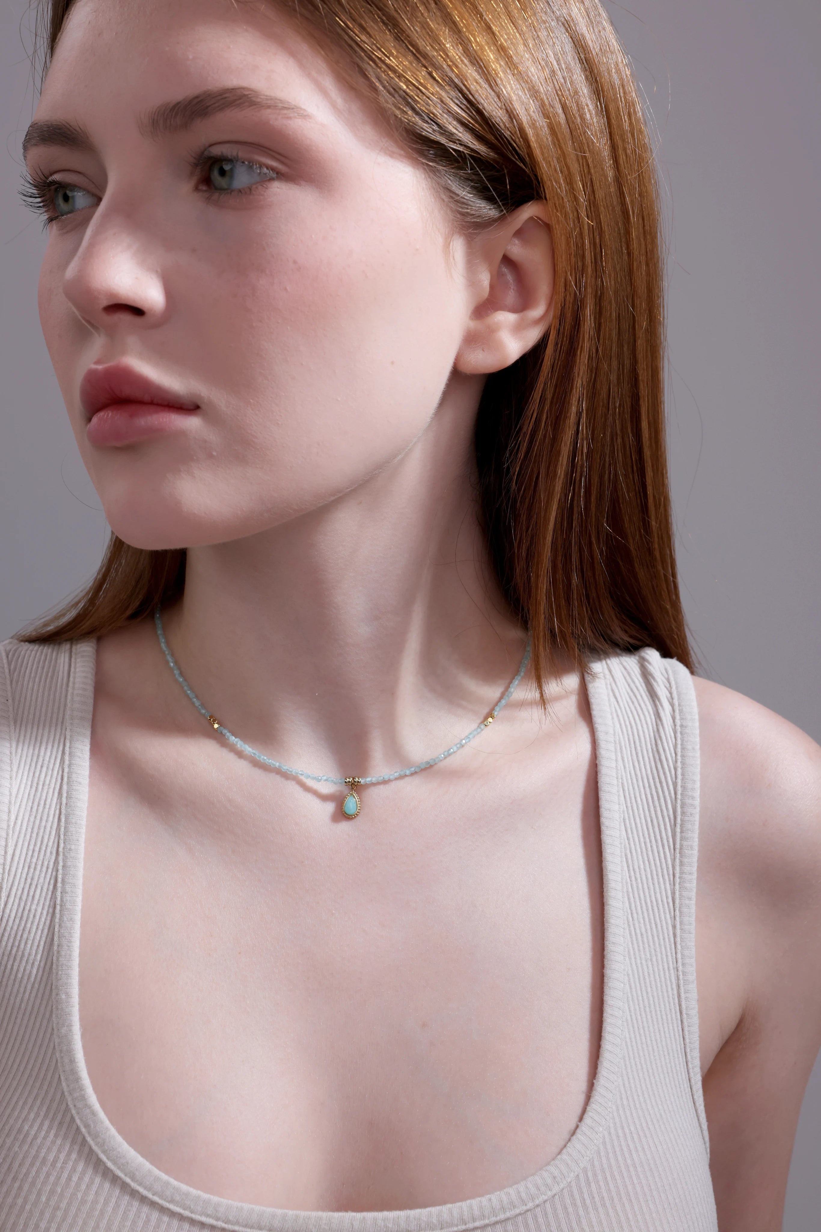 side view of aquamarine beaded necklace with teardrop pendant