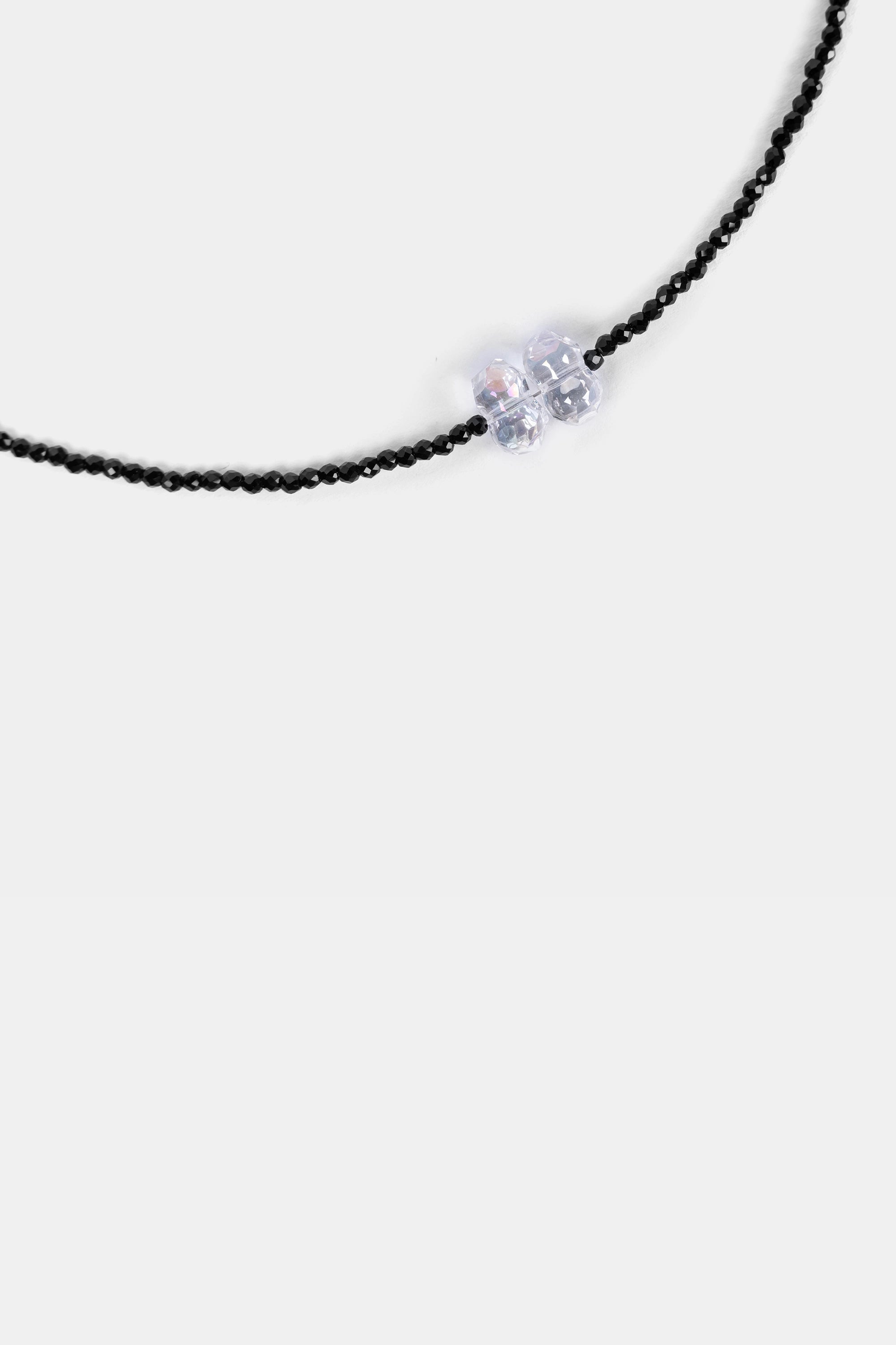close-up of faceted black seed beads with clear crystal bow focal