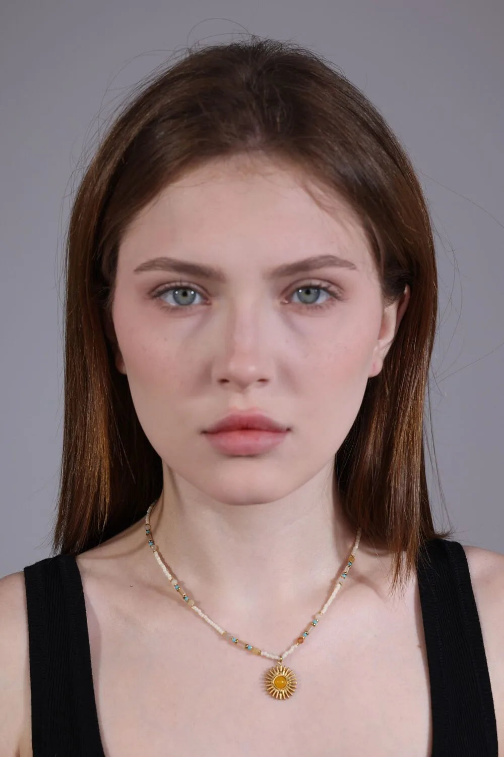 portrait of model with vintage boho sun pendant beaded necklace