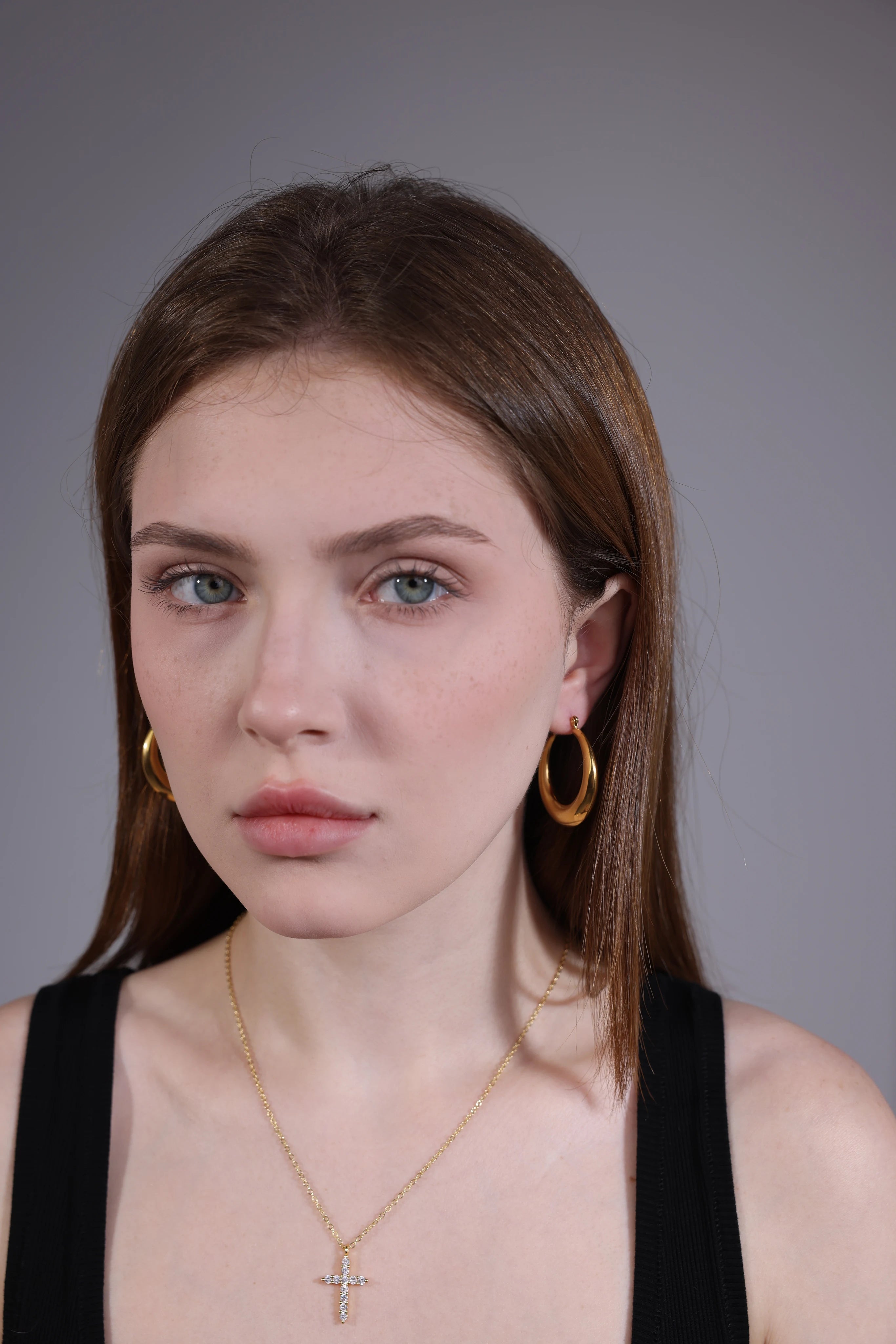 model wearing chunky gold hoop earrings – bold oval hoops jewelry