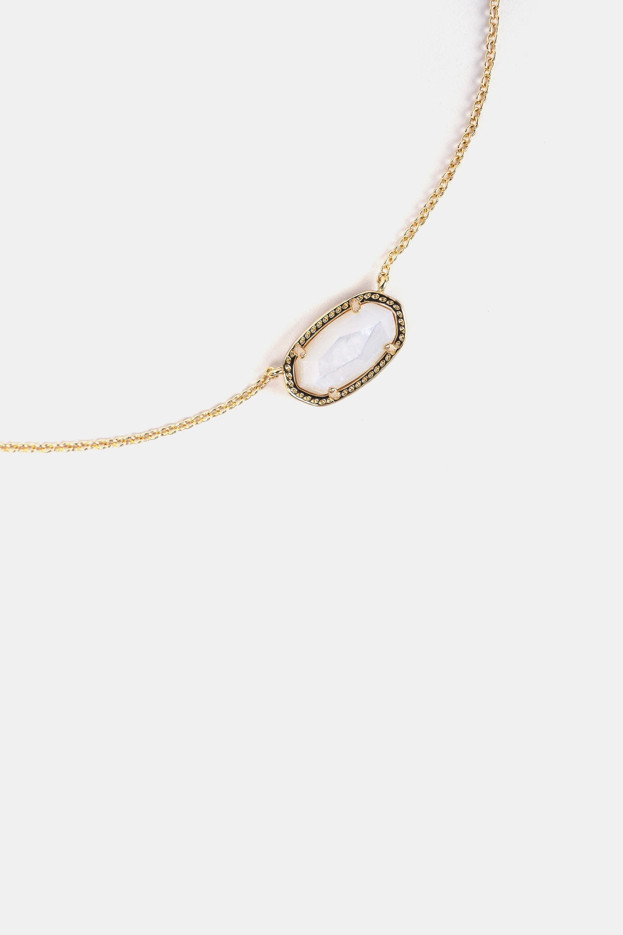 close-up of faceted clear quartz pendant with gold frame