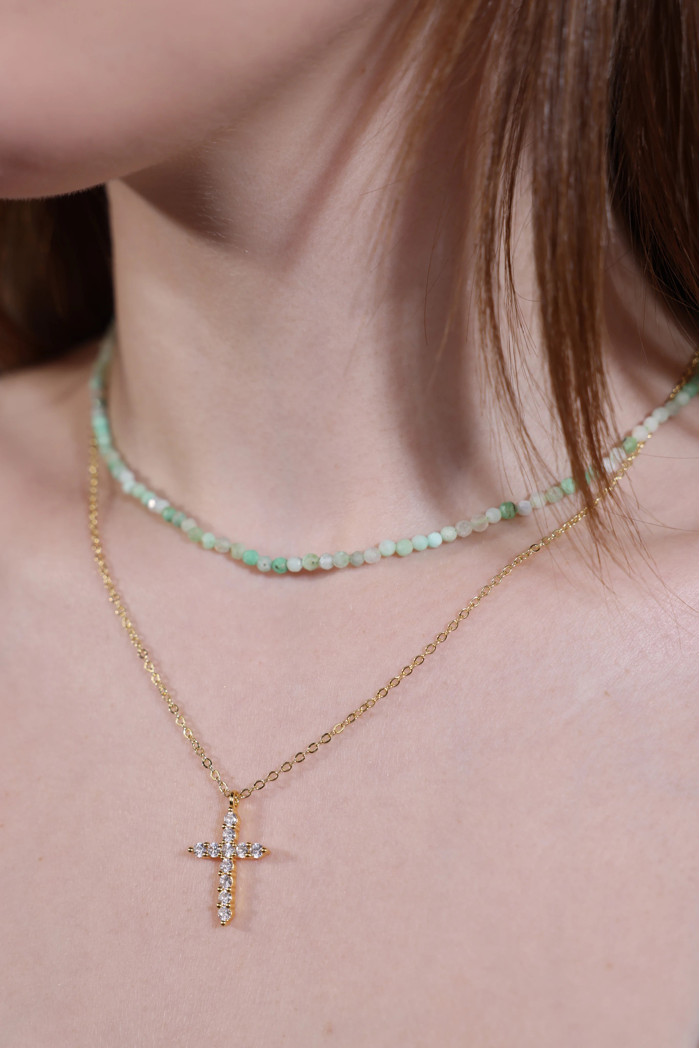 gold cross pendant necklace layered with beaded choker