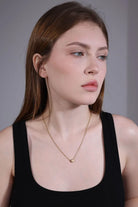 side view of gold heart initial necklace A on model