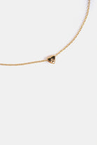 close-up of gold heart pendant with engraved A initial