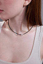 model wearing black beaded choker with crystal bow – minimalist style