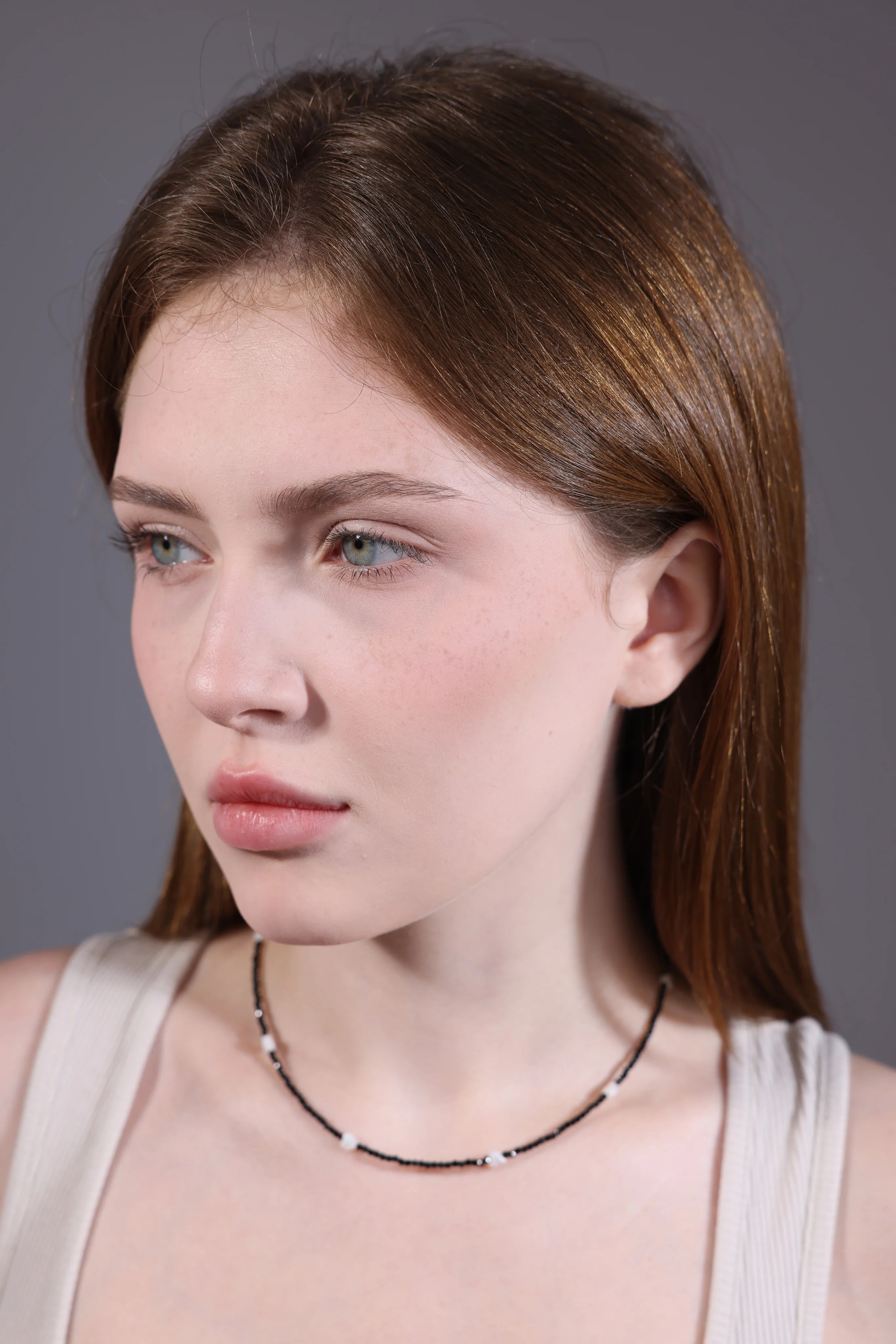 model wearing black beaded choker with shell heart accents – side view