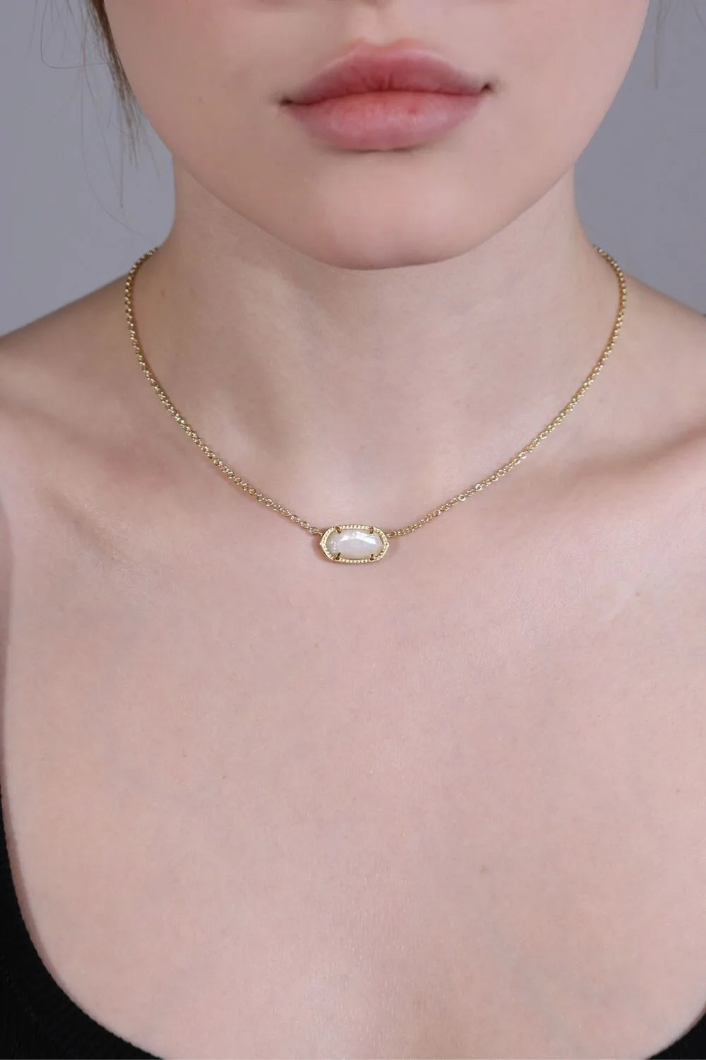 side view of clear quartz pendant necklace with gold chain