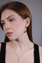 model wearing dainty gold cross pendant necklace – minimalist style