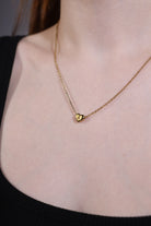 model wearing dainty gold heart initial necklace A