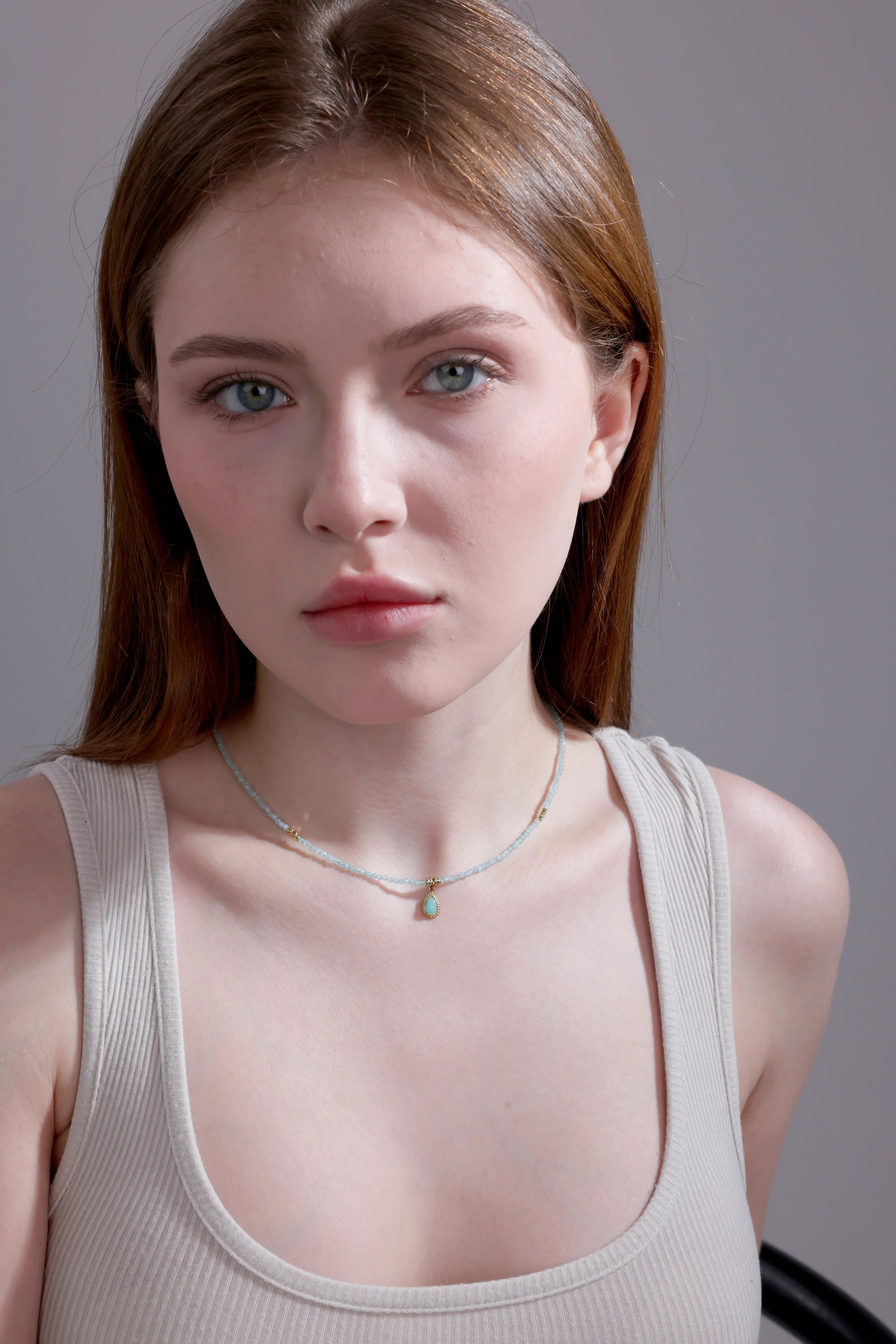 model wearing aquamarine beaded choker with teardrop pendant – minimalist jewelry