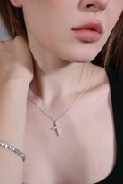 model wearing dainty silver cross necklace – minimalist style