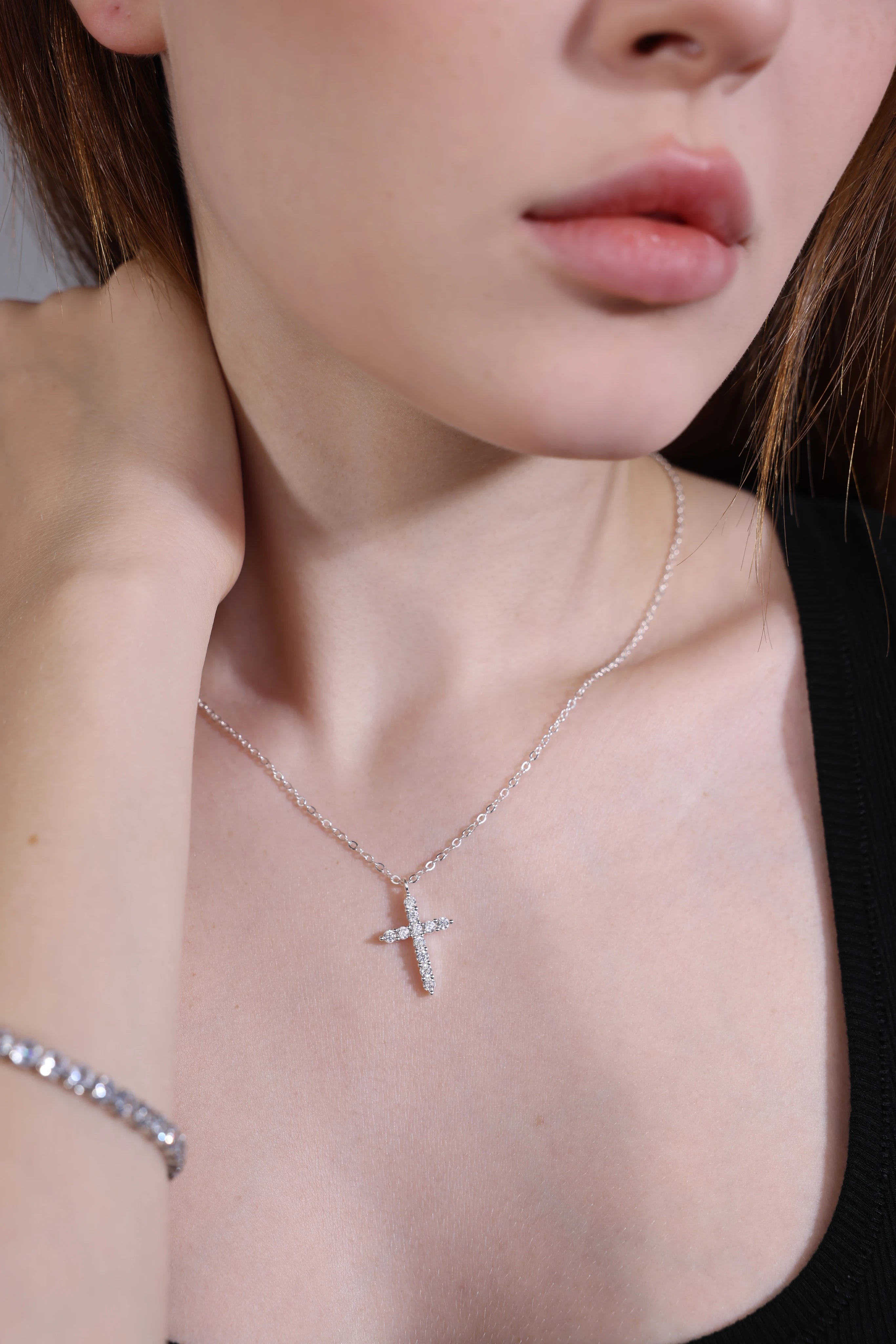 Model wearing dainty silver cross pendant necklace – minimalist style