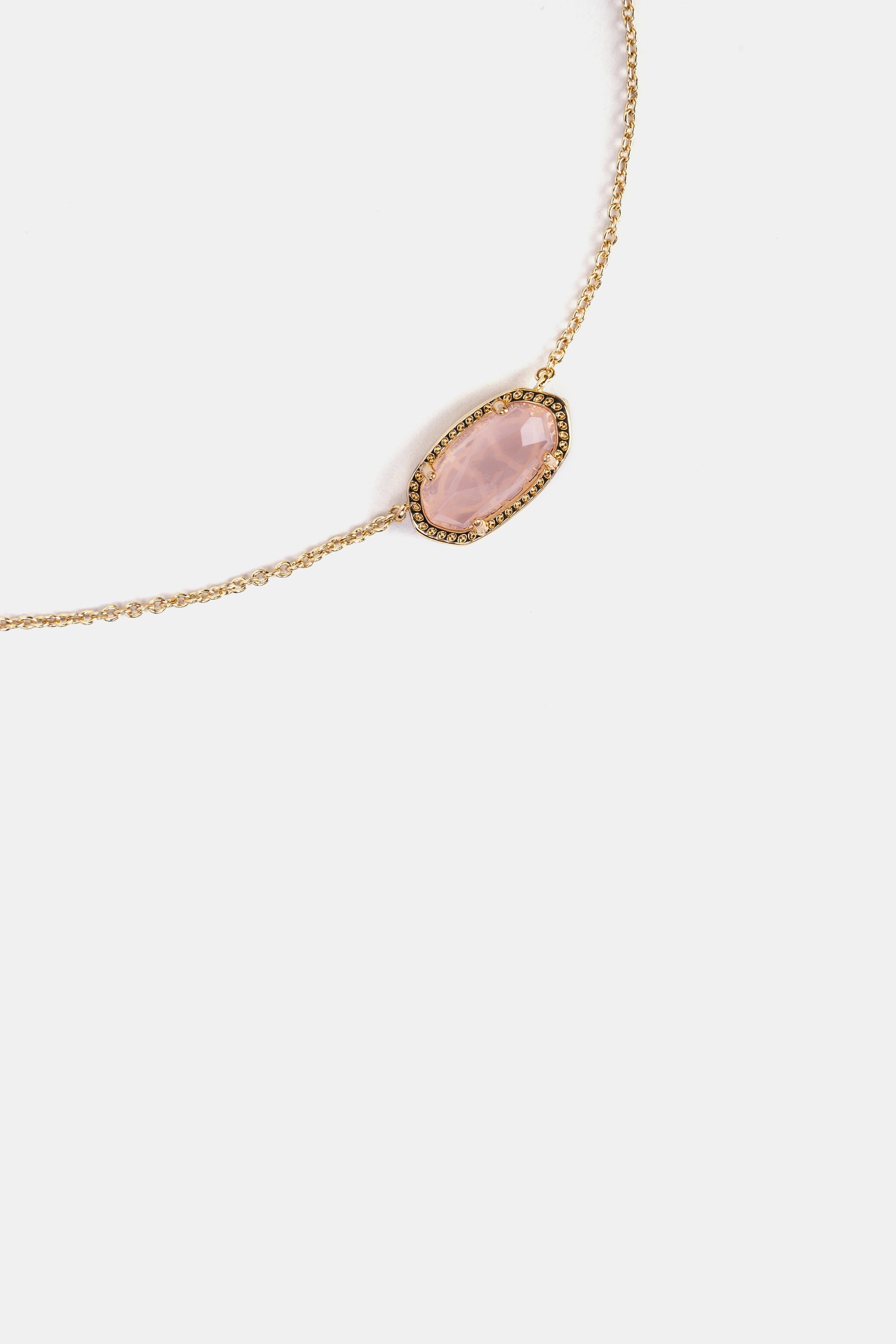 close-up of faceted rose quartz pendant with gold frame