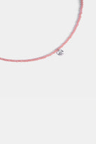 close-up of micro-faceted rose quartz beads with clear quartz drop