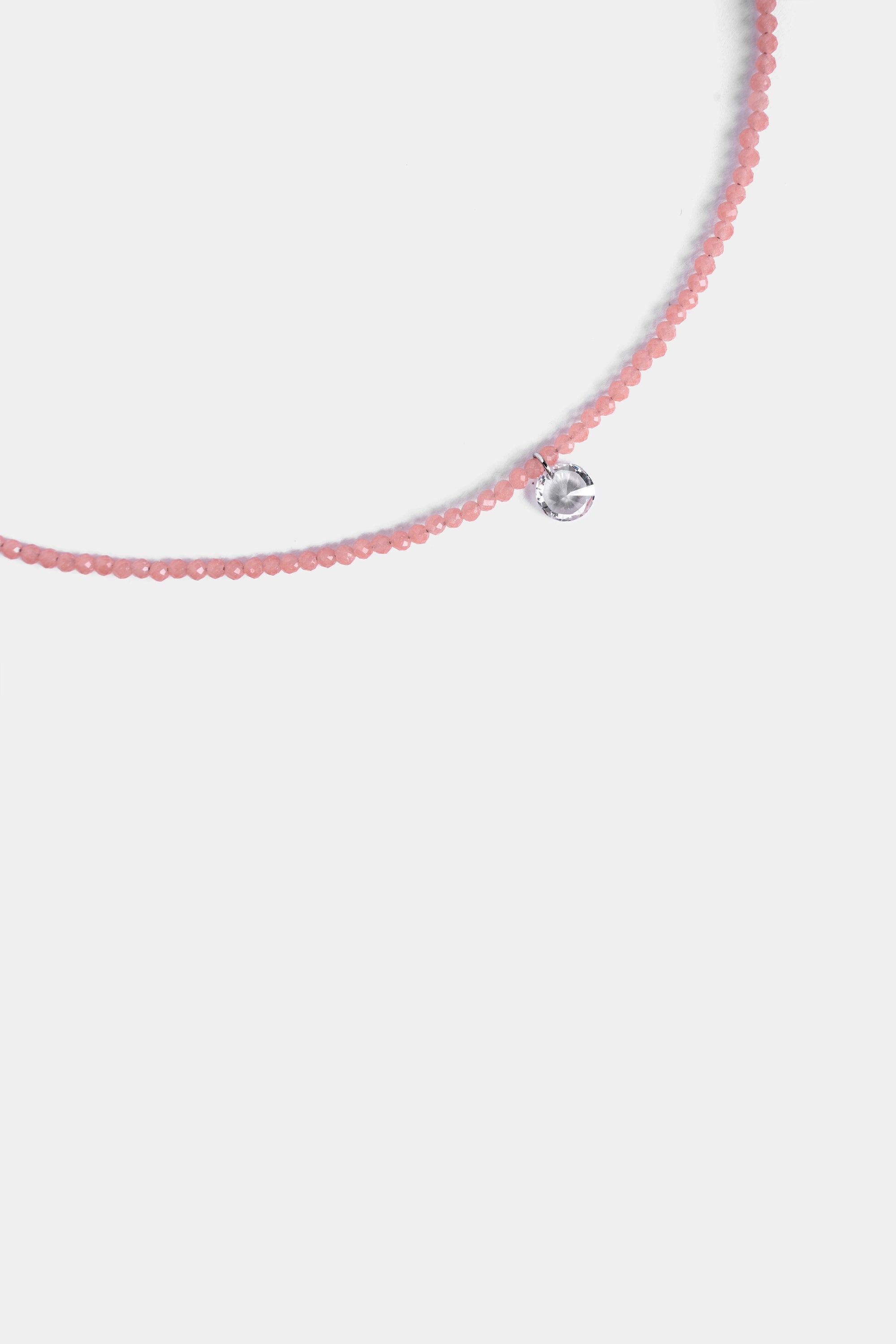 close-up of micro-faceted rose quartz beads with clear quartz drop