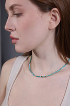 Side profile wearing tiny turquoise faceted bead choker for everyday style