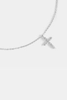 close-up of cubic zirconia cross pendant with silver chain