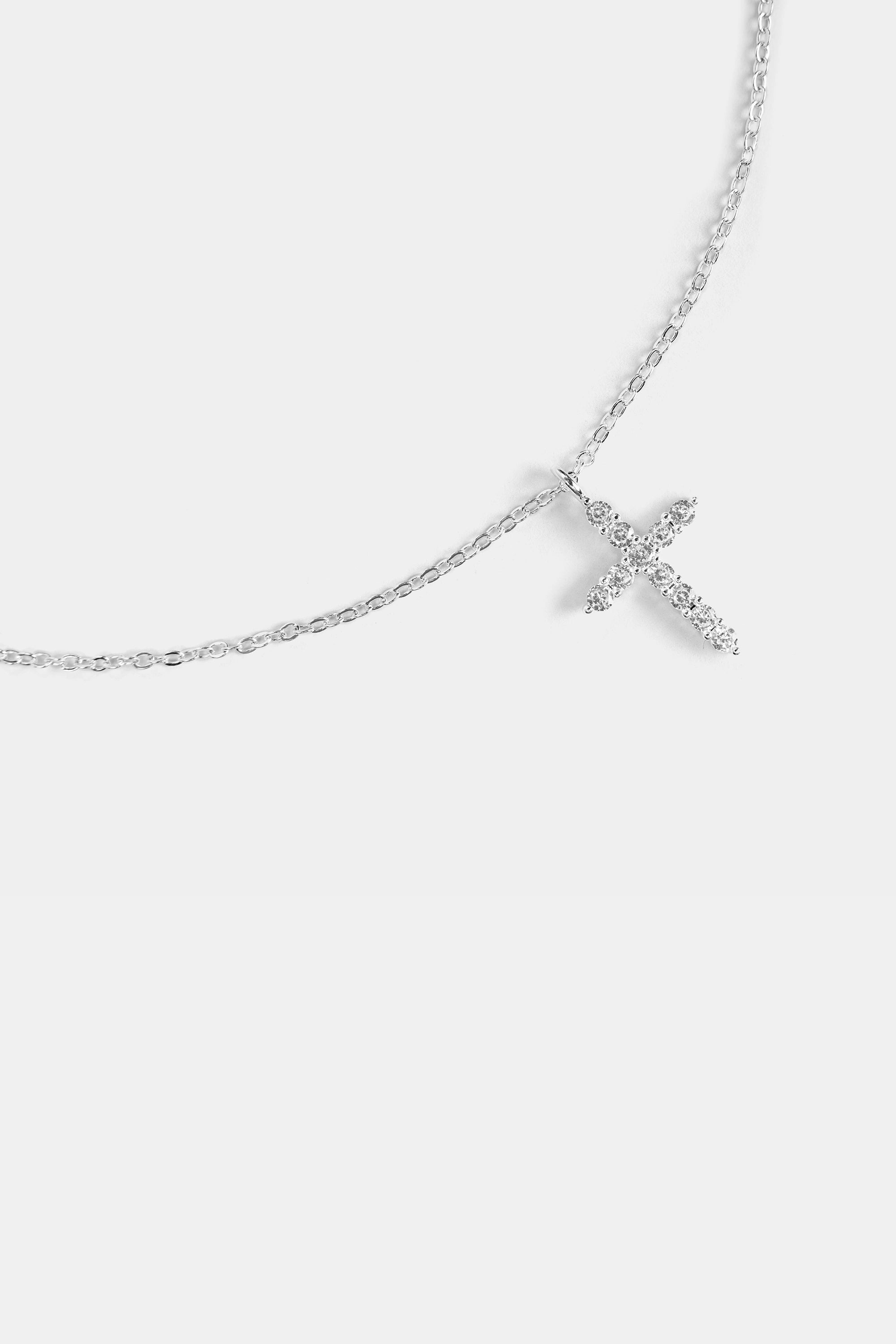 close-up of cubic zirconia cross pendant with silver chain