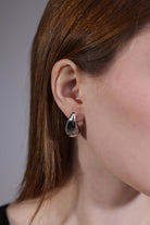 close-up of silver stainless steel teardrop hoop earrings – high polish finish