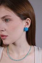side view of sky blue hydrangea crystal earrings on model