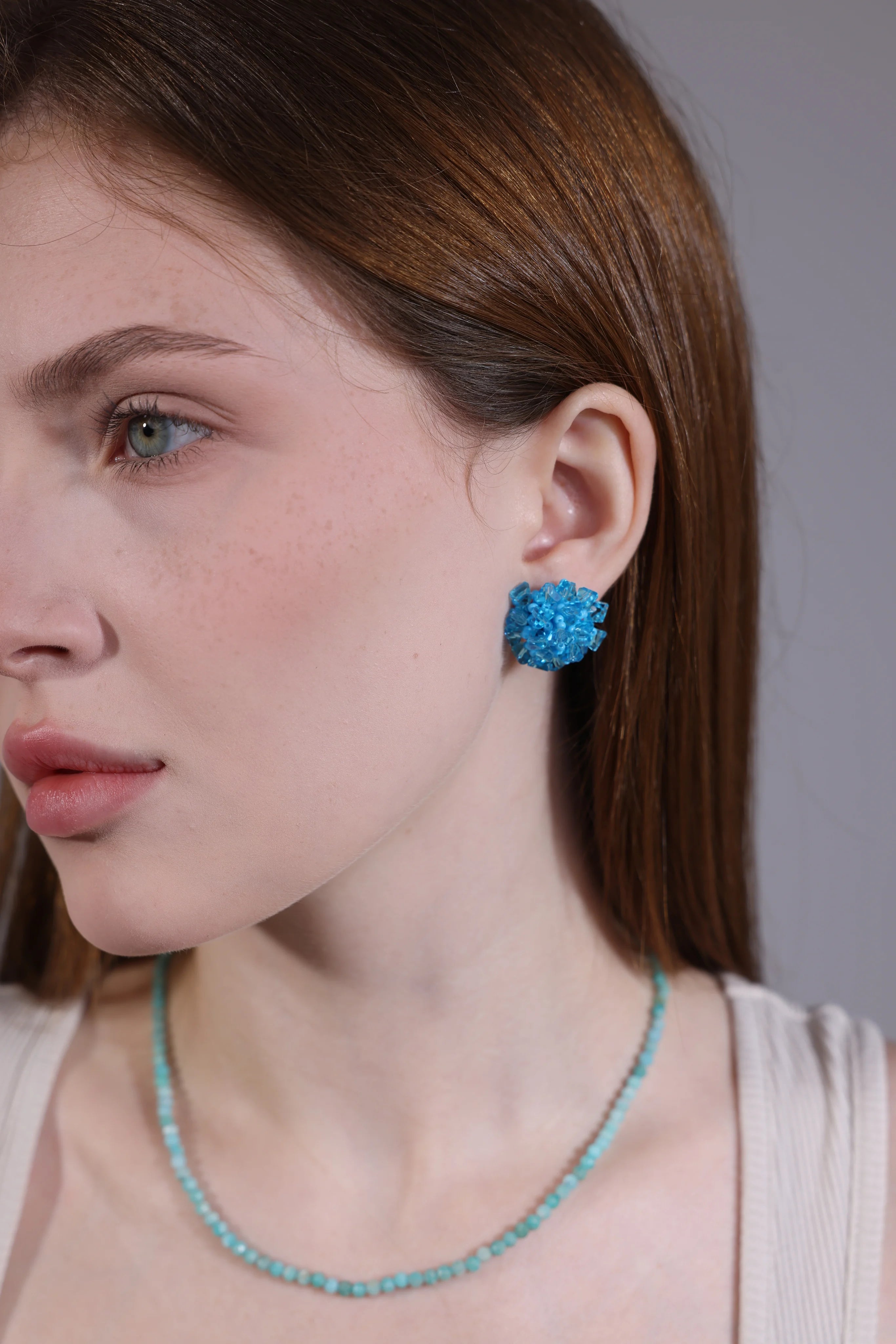 side view of sky blue hydrangea crystal earrings on model