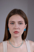 portrait of model with sky blue hydrangea beaded earrings