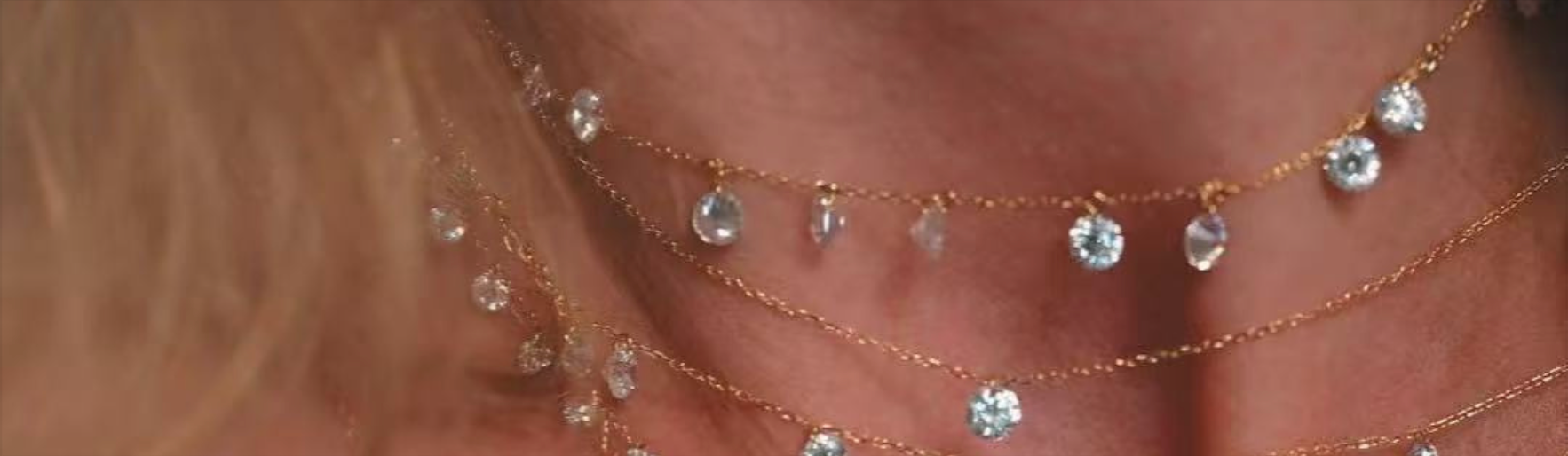 Velvet Luminance about us banner featuring dainty 18K gold plated crystal necklaces layered on model