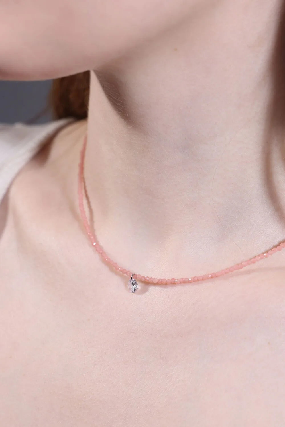 close-up clear quartz charm on rose quartz beaded choker 