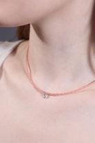 close-up clear quartz charm on rose quartz beaded choker 