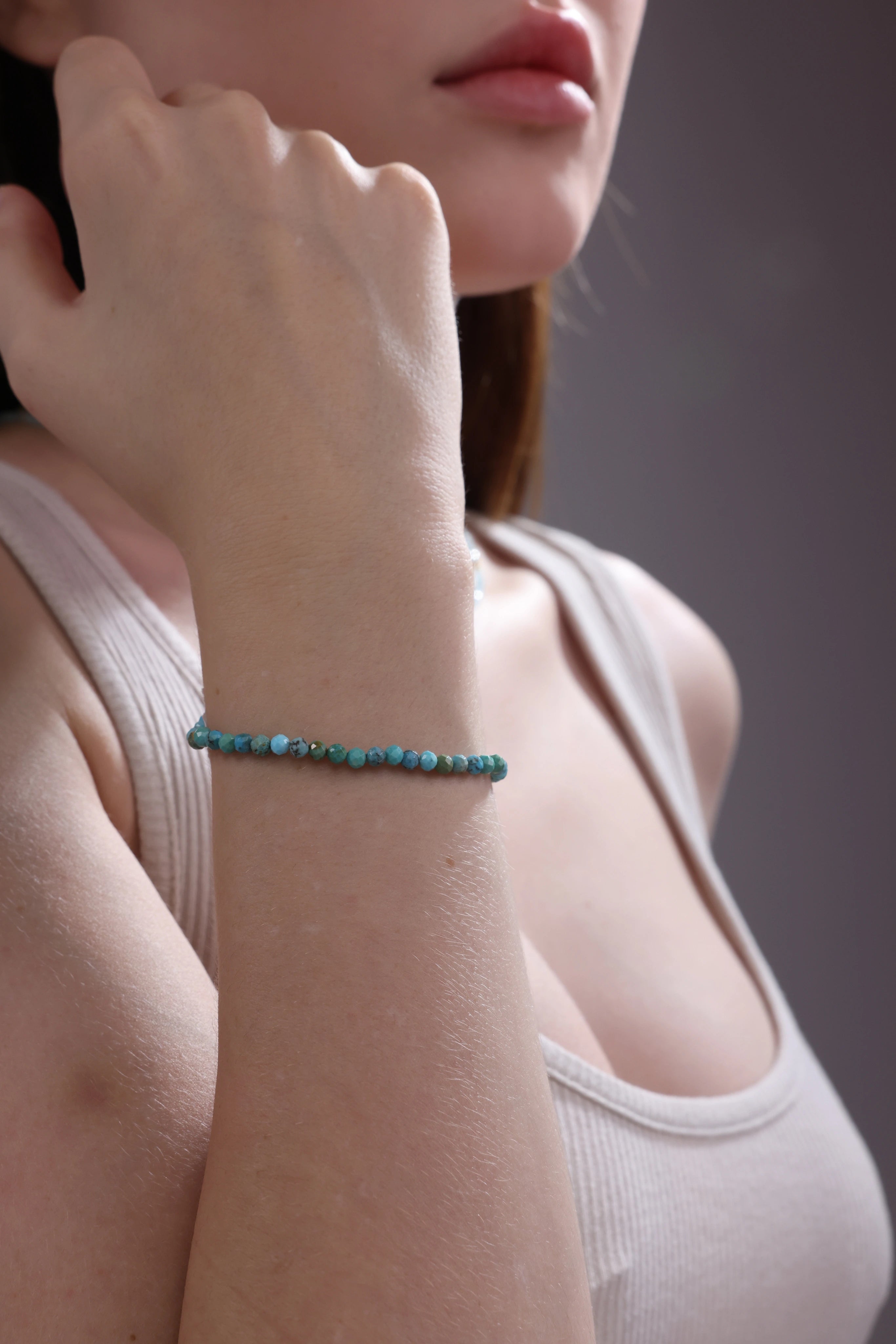 woman styling turquoise gemstone bracelet – 18k gold clasp jewelry