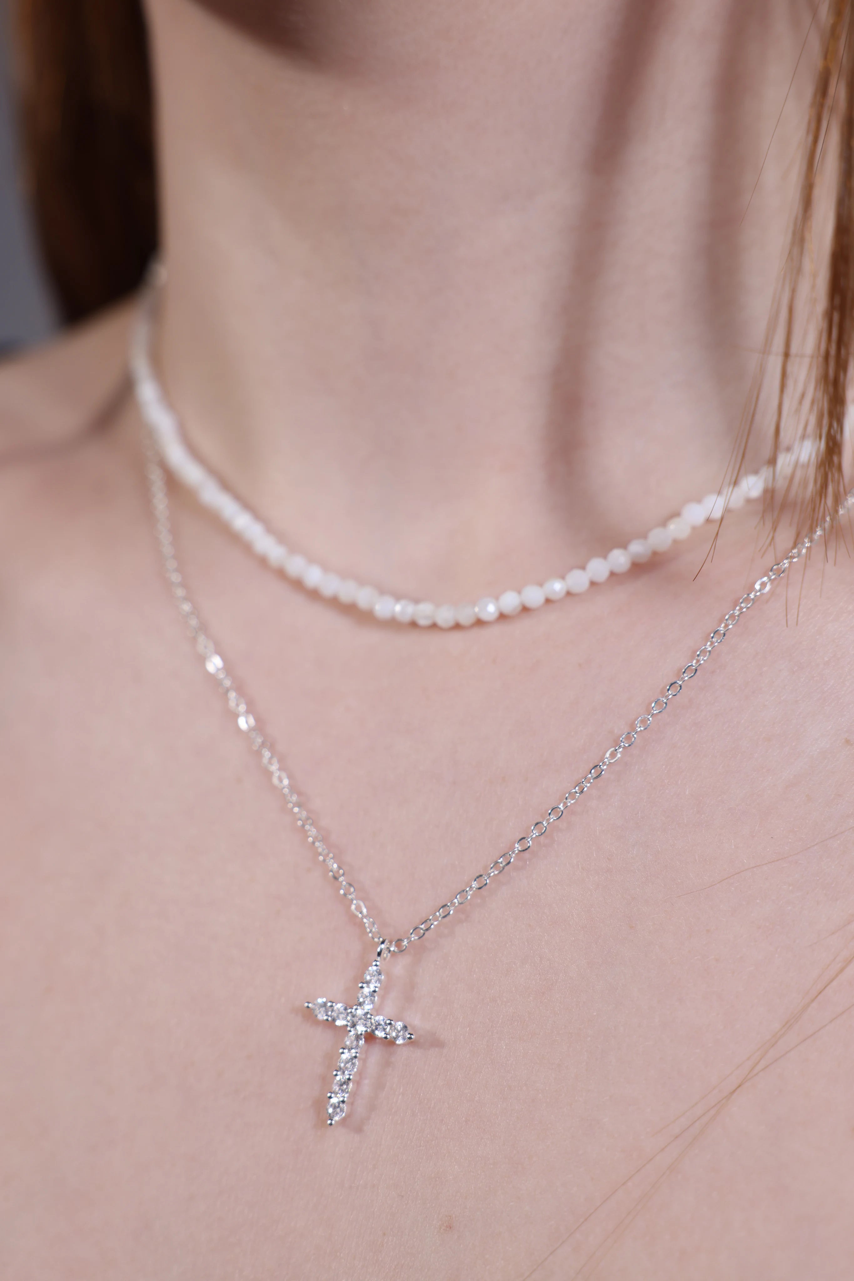 Layered look with silver cross pendant necklace and bead choker