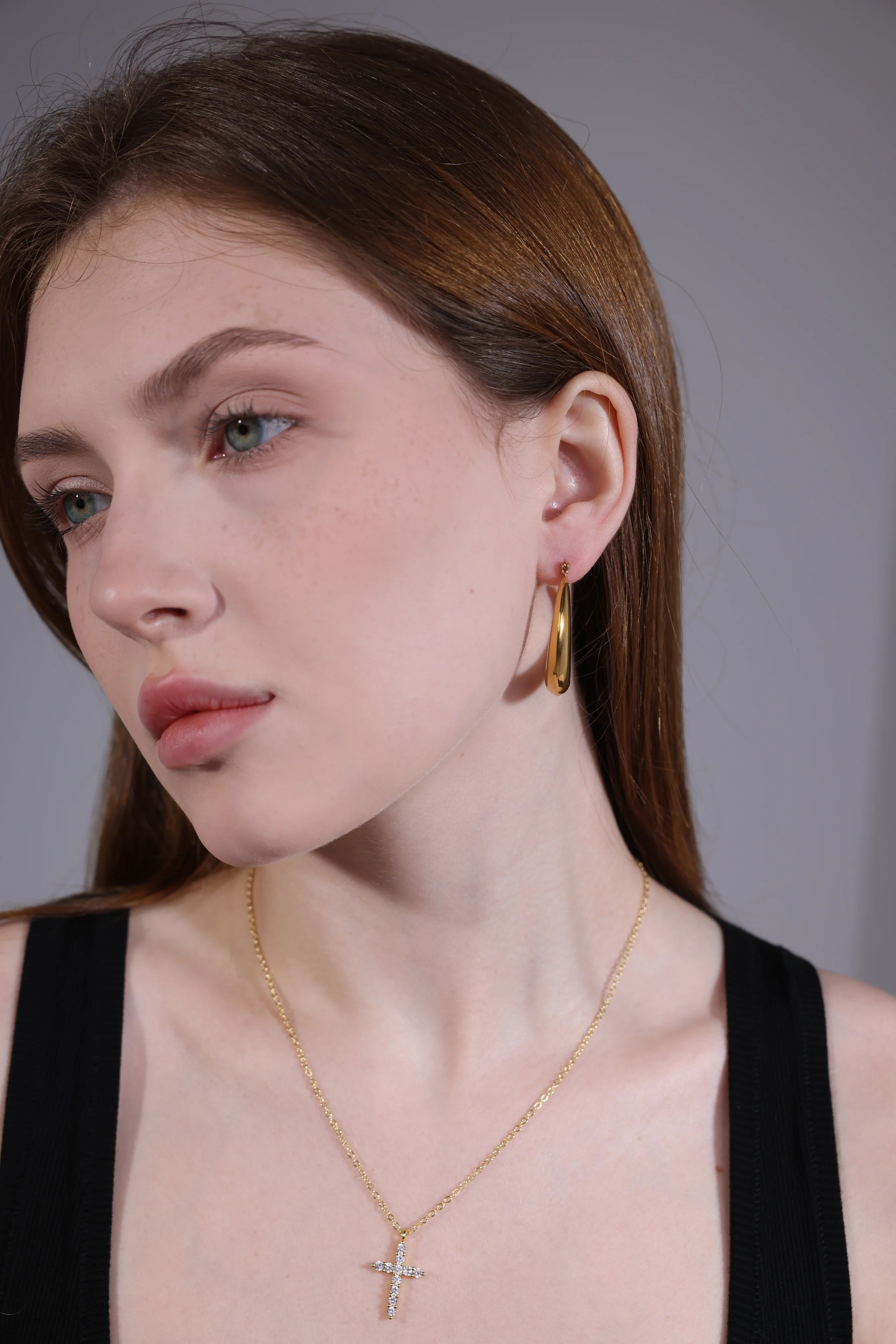 Model wearing dainty gold cross pendant necklace – minimalist style