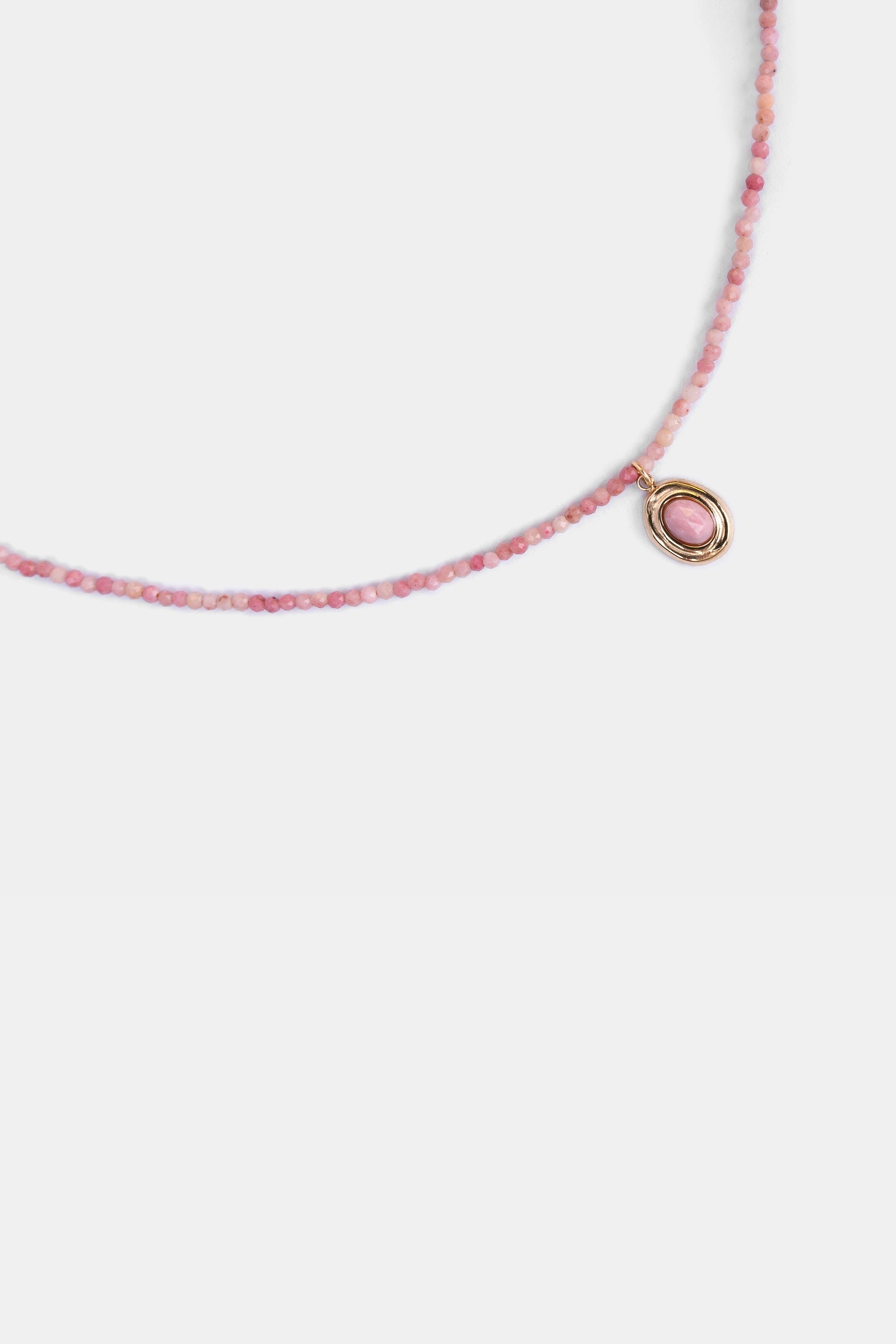 close-up of faceted pink opal beads with oval pendant
