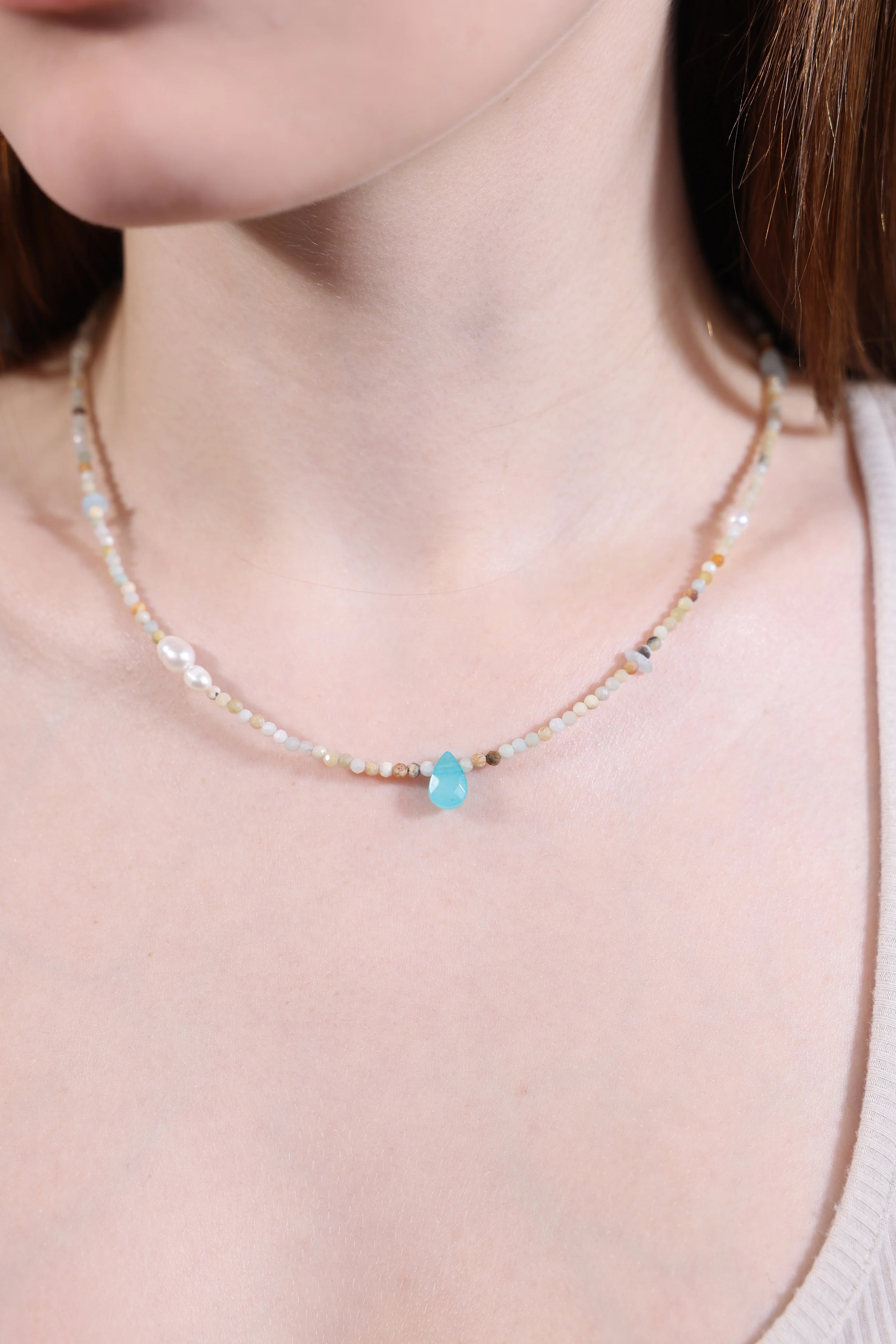 close-up of model wearing turquoise gemstone pendant necklace